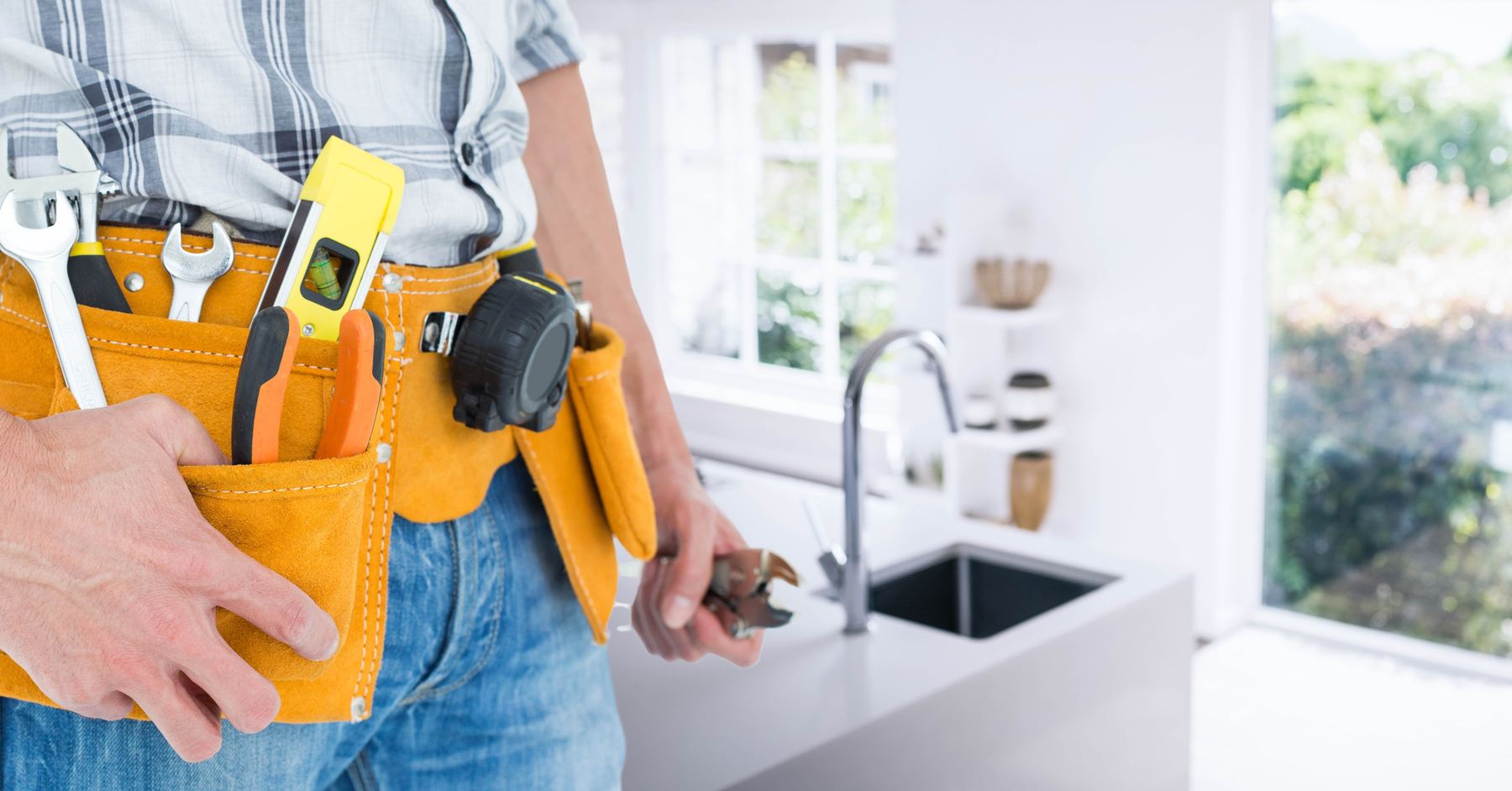 Finish carpenter with tool belt in a renovated kitchen